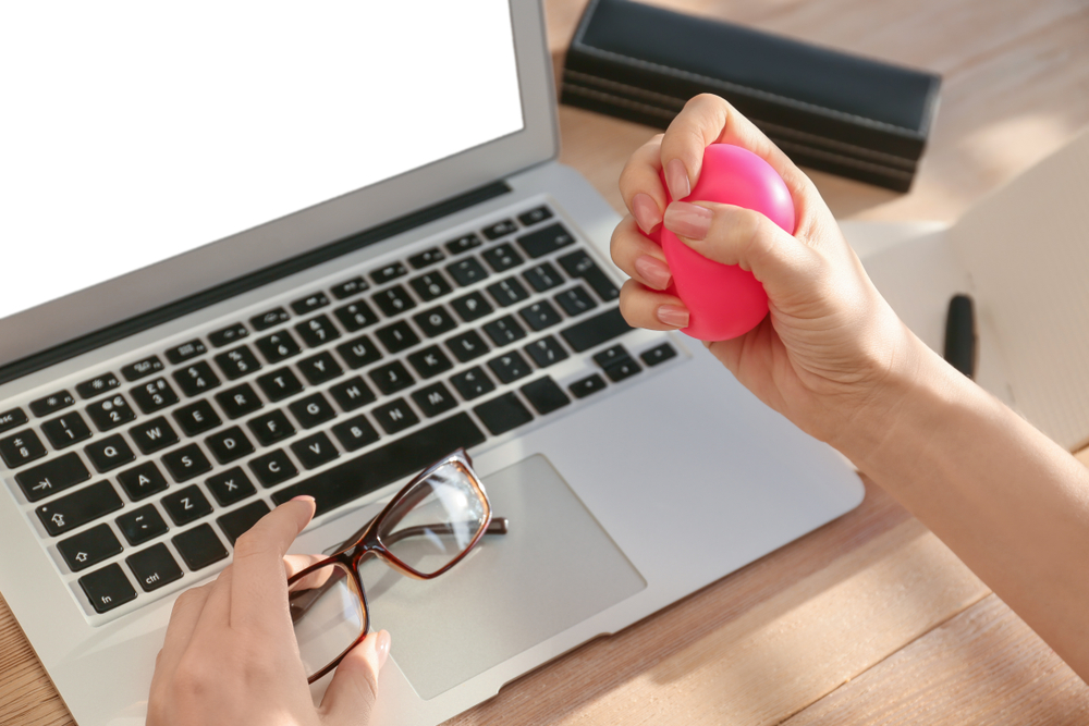 employee squeezing stress ball at work