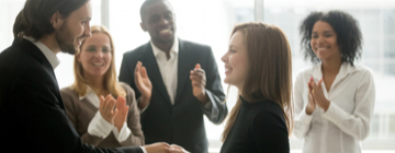 boss promoting employee shaking their hand