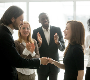 boss promoting employee shaking their hand