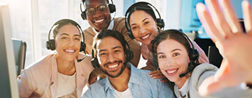 Smiling customer service team taking a group selfie at a call center, illustrating career growth, teamwork, and workplace success.