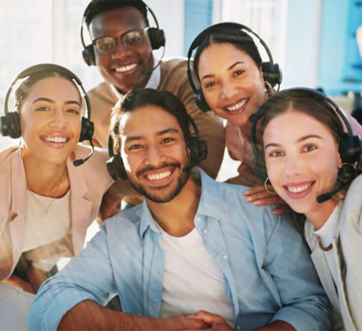Smiling customer service team taking a group selfie at a call center, illustrating career growth, teamwork, and workplace success.