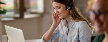 Smiling agent on a headset reviews notes while using small talk to create a friendly and effective customer call experience-1