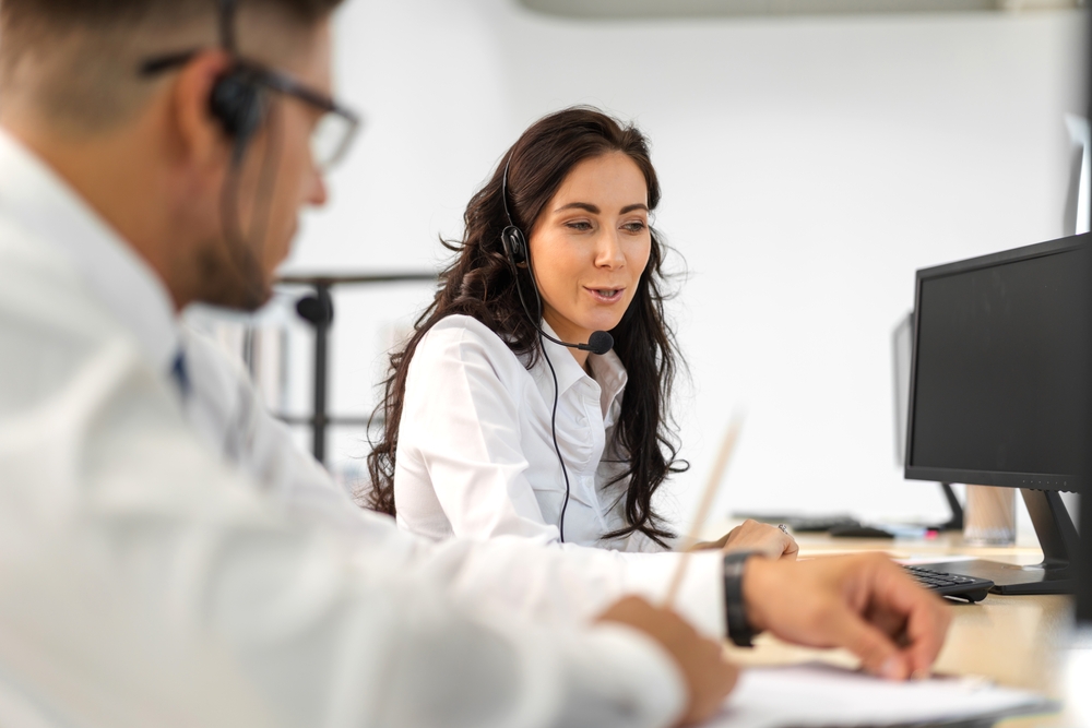 call center agent on phone with customer at desk