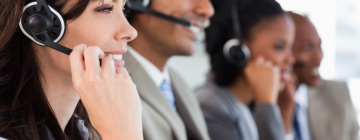 call center workers smiling as they talk to customers