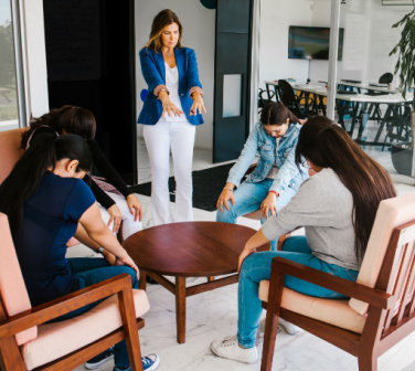 Group of workers do chair yoga at the office