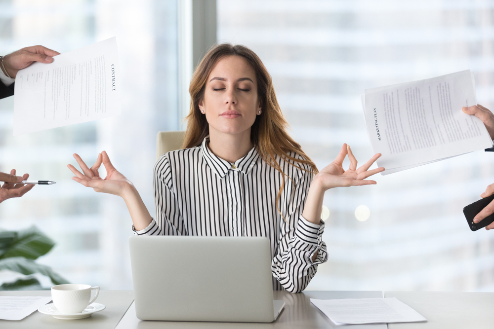 Female employee practicing yoga to deal with stress