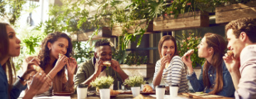 Group of coworkers eat lunch together outside - working at Seguros Confie