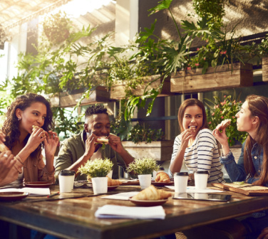 Group of coworkers eat lunch together outside - working at Seguros Confie