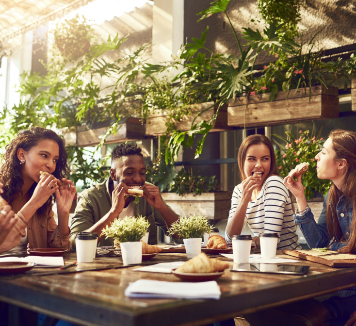 Group of coworkers eat lunch together outside - working at Seguros Confie