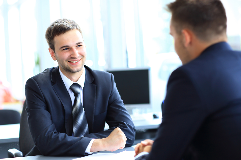 Young man interviews for a job with a manager - careers at Seguros Confie