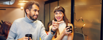 Two colleagues talk together with morning coffee - best call center jobs in Tijuana