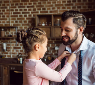 Litttle girl adjusting her daddy's tie as he gets ready for a job interview - call center jobs in Tijuana