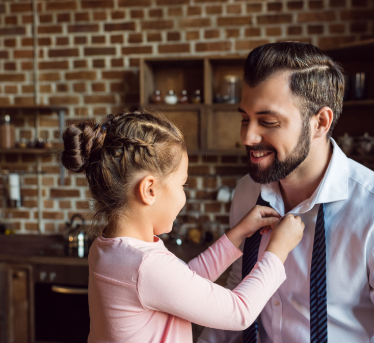 Litttle girl adjusting her daddy's tie as he gets ready for a job interview - call center jobs in Tijuana