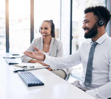 Smiling call center workers discuss their scripts and perfect them - call center jobs in Tijuana.