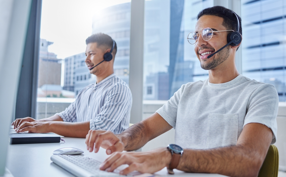 Two smiling co-workers and sales reps at a call center - best call center jobs in Tijuana.