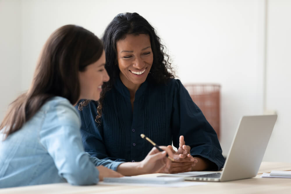 Smiling HR worker explains employee benefits to new hire, best call center in Tijuana.