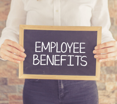 Call center worker holding a sign that has employee benefits written on it, concept of employee benefits, best call center in Tijuana
