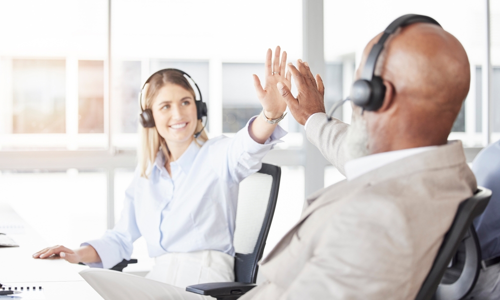 Two call center workers high-five - good call center jobs in Tijuana.