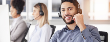 Call center employee smiling young Hispanic male - good jobs at a call center in Tijuana.