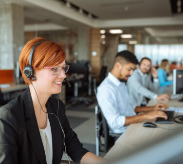 Smiling call center workers on the phone with customers, best call center jobs in Tijuana.
