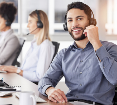 Call center employee smiling young Hispanic male - good jobs at a call center in Tijuana.