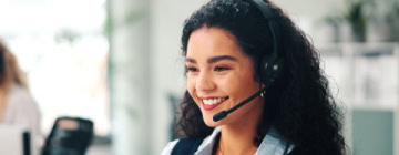Call center, headset and woman with smile, consultation and help desk with system solution. Happy person, employee and agent in office, discussion and contact us with customer support and feedback.