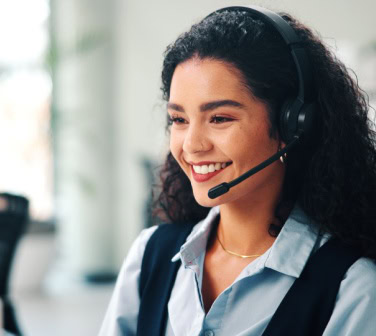 Call center, headset and woman with smile, consultation and help desk with system solution. Happy person, employee and agent in office, discussion and contact us with customer support and feedback.