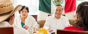 Mexican family celebrate together the day of the independence of Mexico with a traditional dinner. Grandparents, mother and son eat traditional Mexican dishes together during a family reunion.