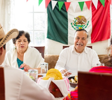 Mexican family celebrate together the day of the independence of Mexico with a traditional dinner. Grandparents, mother and son eat traditional Mexican dishes together during a family reunion.