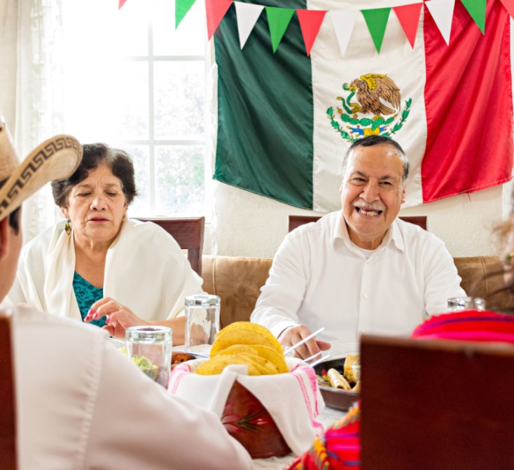 Mexican family celebrate together the day of the independence of Mexico with a traditional dinner. Grandparents, mother and son eat traditional Mexican dishes together during a family reunion.