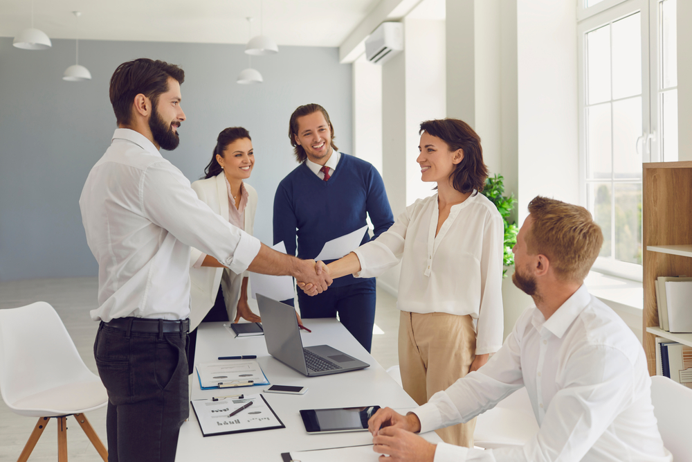 4 Sales representative people doing a group interview of a young woman for a new hire.