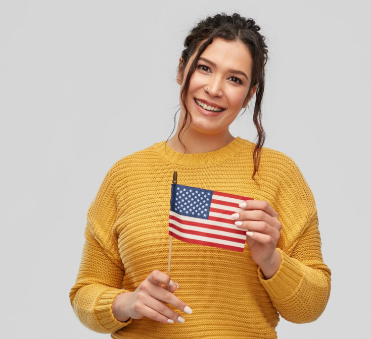 Woman holding a U.S. flag and smiling, symbolizing bilingual speakers connected to American culture and language-1