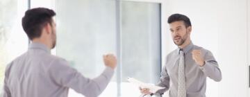 A young man looking in the mirror and giving himself a pep talk, positive self talk.