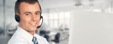 Handsome young man wearing a headset and working in a fun Tijuana-based call center.