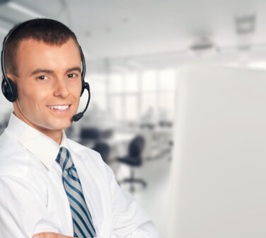 Handsome young man wearing a headset and working in a fun Tijuana-based call center.