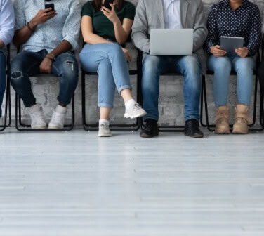 A view of the legs of a variety of job seekers waiting for an interview - best call center in Tijuana.