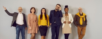 Smiling business people in a line showing appropriate dress for success.