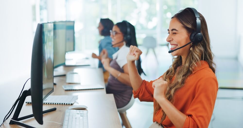 Female call center agent celebrating when a customer is happy.
