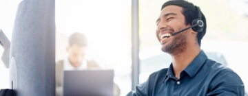 Customer service rep smiling with a headset on.