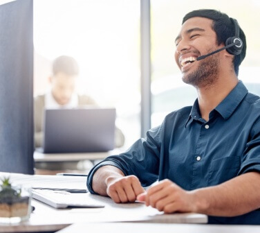 Customer service rep smiling with a headset on.