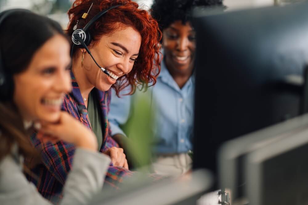A team of female call center agents laughing and enjoying while they work.