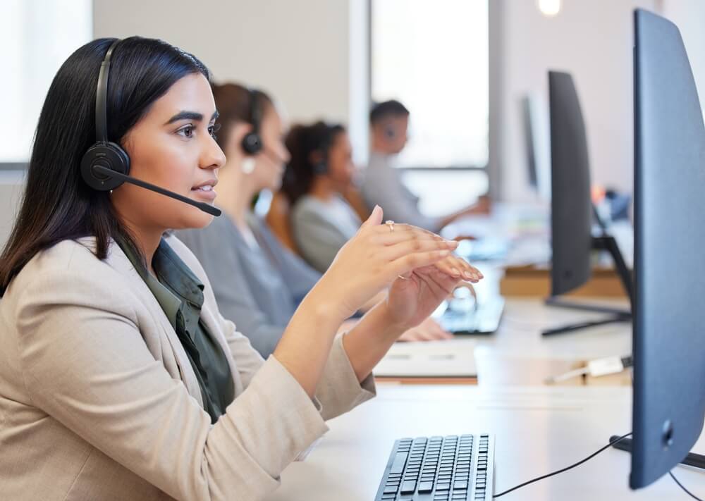 Hispanic woman call center rep talking to customer on the phone wearing a head set.
