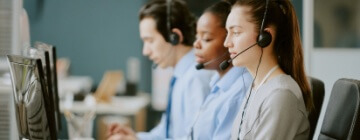 Line of call center workers with headsets, talking to customers - best call center jobs in Tijuana.