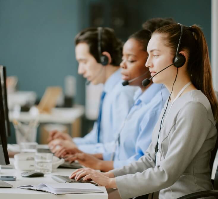 Line of call center workers with headsets, talking to customers - best call center jobs in Tijuana.