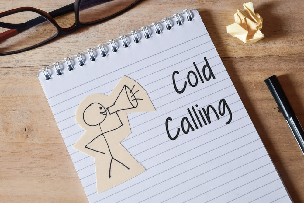 A notebook with a stick figure man holding a megaphone, cold calling written on notebook - best call center jobs in Tijuana.