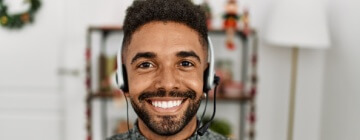 Smiling man faces camera with headset on, taking and making calls - best call center in Tijuana.