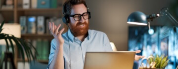 Businessman working in admin in a call center wears a headset and talks to customers - best call center in Tijuana.