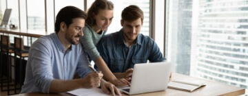 Two male and one female call center colleagues help each other master new skills - best call center jobs in Tijuana.