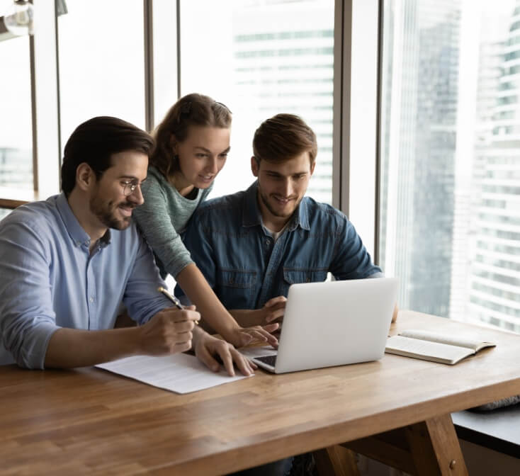 Two male and one female call center colleagues help each other master new skills - best call center jobs in Tijuana.