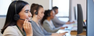 A line of call center agents working with customers, speaking into headsets - coolest call center in Tijuana.